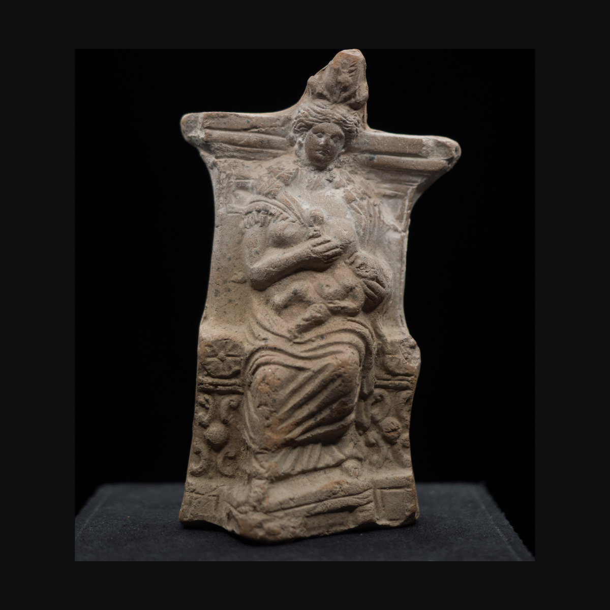 Statuette représentant une isis lactans assise sur un trône.Elle tient Harpocrate et lui tend son sein gauche.